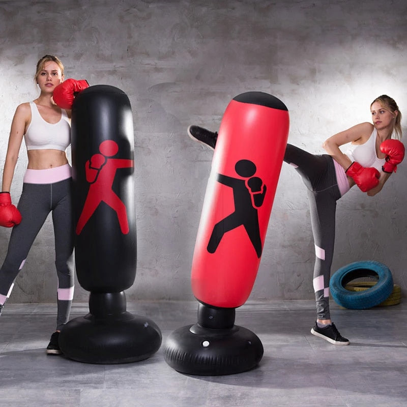 Woman practicing boxing with inflatable punching bags in a gym setting