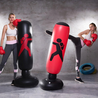 Woman practicing boxing with inflatable punching bags in a gym setting