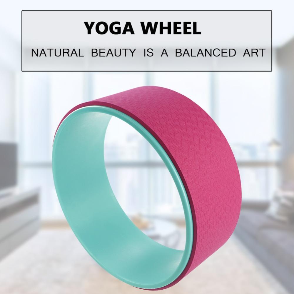 Pink and green yoga wheel with a blurred indoor background and text overlay.