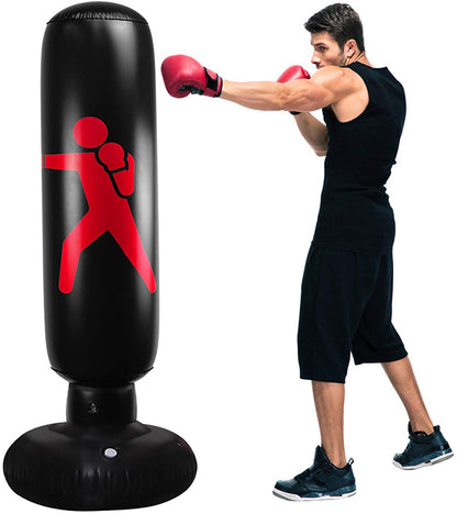Person wearing boxing gloves and shorts, punching a black punching bag with a red logo.