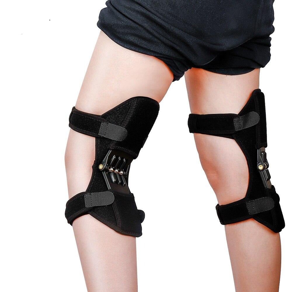 Black knee brace on a person's legs against a white background