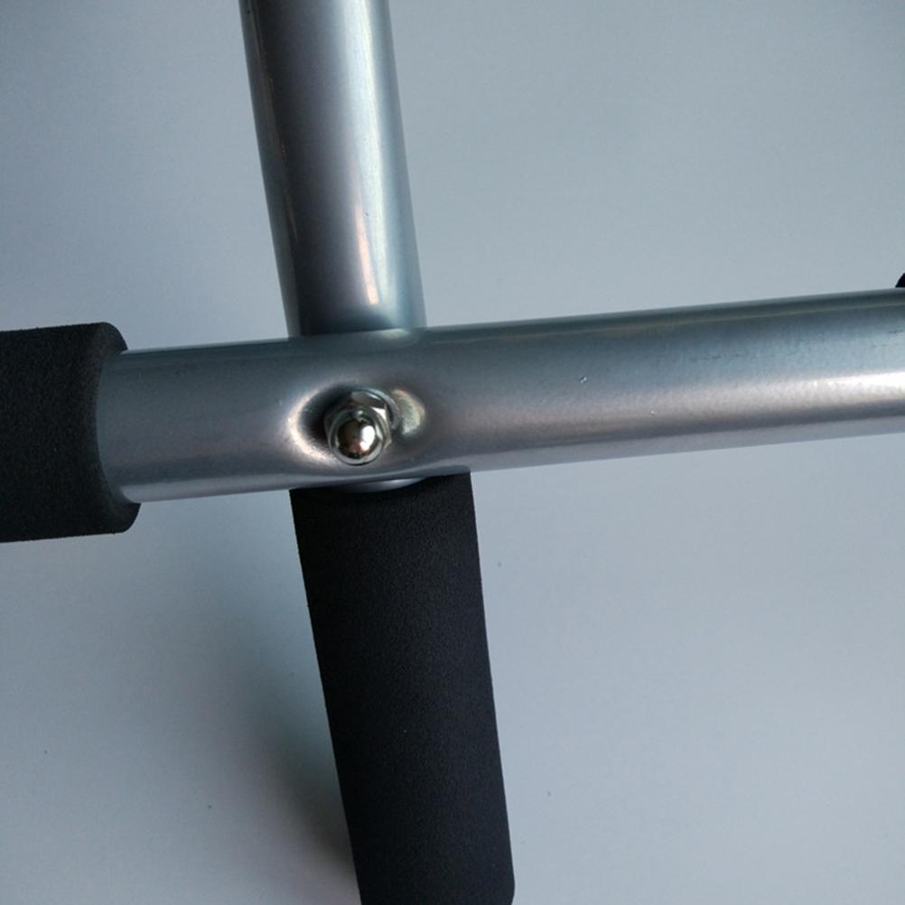 Close-up of a metal handlebar with a screw on a gray background